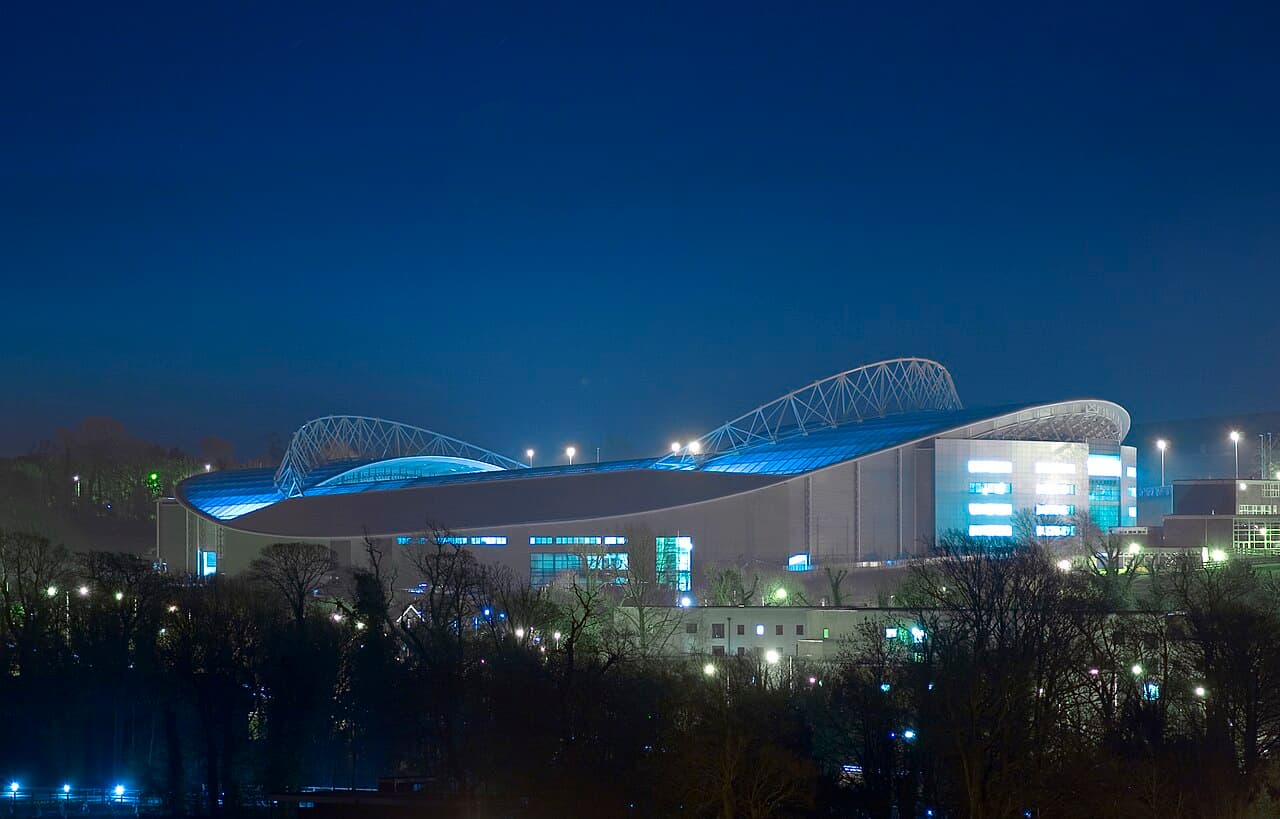 Blick auf ein leeres Fußballstadion mit grünem Rasen und leeren Tribünenrängen vor Spielbeginn