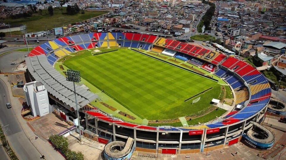 A football stadium with green pitch and stands ready before the Deportivo Pasto vs Fortaleza CEIF match